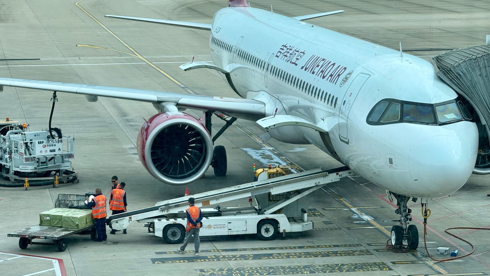 Ground crew loading cargo beside a commercial airplane